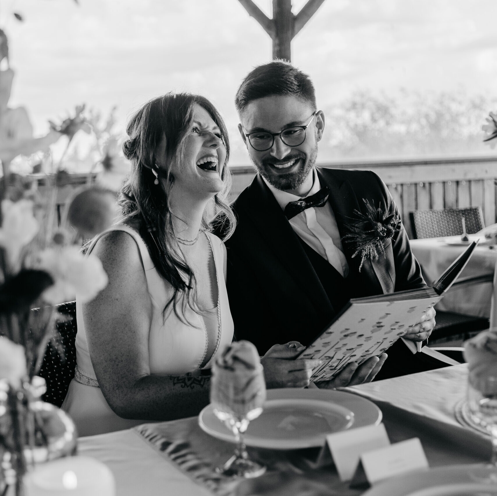 Hochzeitspaar lacht ausgelassen beim betrachten des Gästebuches Dresden